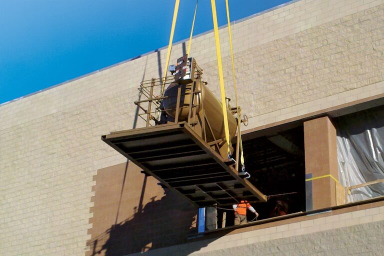 A Fulton Boiler product being delivered by crane into an opening of a building